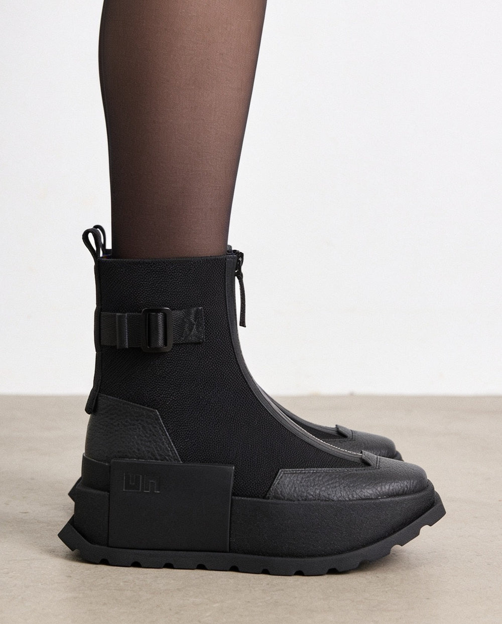 Botas negras de plataforma con cremallera frontal y detalles estilo cargo para mujer. AI generated.